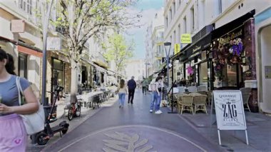 Cannes, Fransa - 28 Nisan 2025: İnsanlar ve arabalar şehrin sokaklarında hareket ediyor