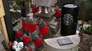 Tapınaktaki birden fazla Japon tilki heykelini kapatın.