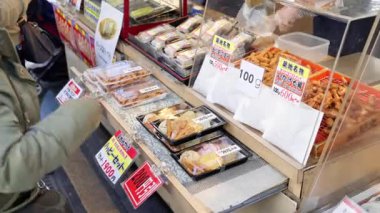 Tokyo, Japonya - 23 Nisan 2025: Japonya 'daki Tsukiji Balık Pazarı' nda satılık plastik kaplarda farklı türde kızarmış deniz ürünleri. Çevirisi: 