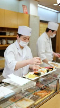 Chuo, Japonya - 23 Nisan 2025: Japonya 'daki Tsukiji Balık Pazarı' nda balık kesen bir aşçıya yakın çekim. Dikey