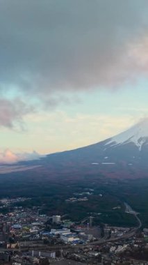 Fuji Dağı 'nın tepesinde karlı ve gün batımında hareket eden bulutlu hava aracı görüntüsü.