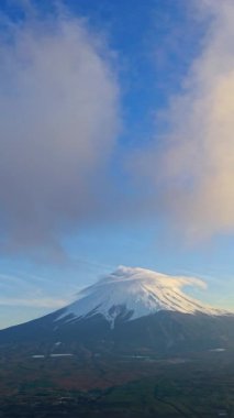 Fuji Dağı 'nın tepesinde kar ve gün ışığında hareket eden bulutlu hava aracı görüntüsü.