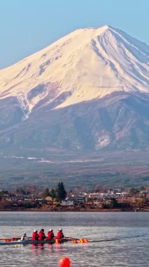 Arka planda Fuji Dağı, Kawaguchiko Gölü 'nde antrenman yapan dört kişilik bir kürek takımının insansız hava aracı görüntüsü.