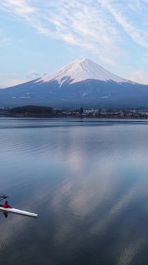 Fujikawaguchiko, Japonya - Arpil 7, 2025: Arka planda Fuji Dağı ile Kawaguchiko Gölü 'nde antrenman yapan dört kişilik bir dümenci takımının hava aracı görüntüsü