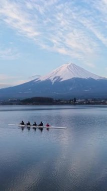 Fujikawaguchiko, Japonya - Arpil 7, 2025: Arka planda Fuji Dağı ile Kawaguchiko Gölü 'nde antrenman yapan dört kişilik bir dümenci takımının hava aracı görüntüsü