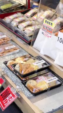 Japonya 'daki Tsukiji Balık Pazarı' nda satılık plastik kaplarda farklı türde kızarmış deniz ürünleri. Dikey. Çevirisi: 