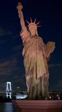 Minato, Japonya - 24 Nisan 2025: Gece Odaiba Özgürlük Anıtı manzarası. Dikey