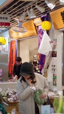 Chuo, Japonya - 23 Nisan 2025: İnsanlar Tsukiji Balık Pazarı 'nda yürüyor. Dikey. Çevirisi: 