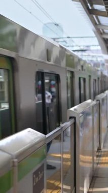 Tokyo, Japonya - 24 Nisan 2025: metro istasyona insanlar beklerken geldi. Dikey