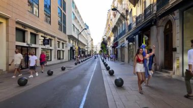 Cannes, Fransa - 23 Ağustos 2024: İnsanlar gün ışığında şehrin sokaklarında mağazaların yakınında yürüyorlar