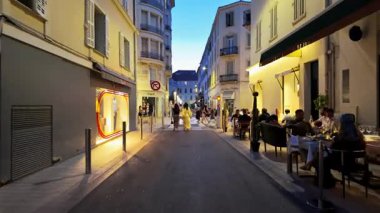 Cannes, Fransa - 24 Ağustos 2024: Sokakta yürüyen insanlar, akşamları terasların yanında