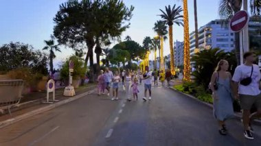 Cannes, Fransa - 24 Ağustos 2024: Akşamları Croisette Bulvarı 'nda yürüyen insanlar