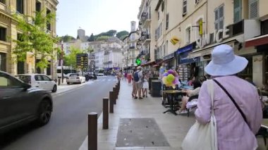 Cannes, Fransa - 26 Ağustos 2024: İnsanlar gün ışığında terasların yanında sokakta yürüyor