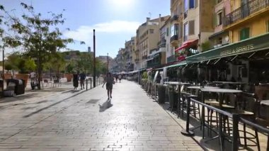 Cannes, Fransa - 26 Ağustos 2024: İnsanlar gün ışığında terasların yanında sokakta yürüyor