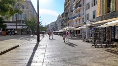 Cannes, Fransa - 26 Ağustos 2024: İnsanlar sokakta, teras ve mağazaların yakınında gün ışığında yürüyor