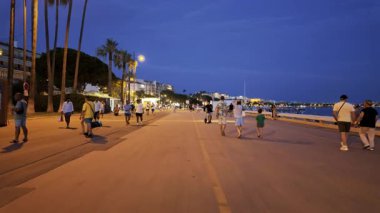 Cannes, Fransa - 26 Ağustos 2024: İnsanlar akşam saatlerinde şehrin sokaklarında yürüyor