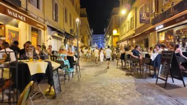 Cannes, Fransa - 26 Ağustos 2024: İnsanlar sokakta yürüyor, akşamları terasların yanında