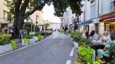 Antibes, Fransa - 29 Ağustos 2024: İnsanlar gün ışığında şehrin sokaklarında teraslarda oturuyorlar