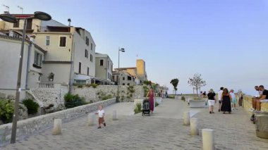 Antibes, Fransa - 29 Ağustos 2024: Sahildeki farklı binaların etrafında yürüyen insanların görüntüsü