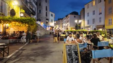 Antibes, Fransa - 29 Ağustos 2024: İnsanlar akşam saatlerinde şehrin sokaklarında teraslarda oturuyorlar