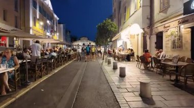 Antibes, Fransa - 29 Ağustos 2024: İnsanlar akşam saatlerinde şehrin sokaklarında teraslarda oturuyorlar