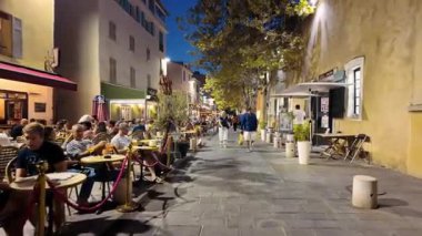 Antibes, Fransa - 29 Ağustos 2024: İnsanlar akşam saatlerinde şehrin sokaklarında teraslarda oturuyorlar