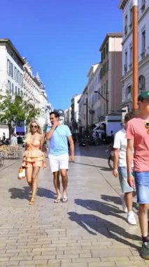 Cannes, Fransa - 23 Ağustos 2024: İnsanlar gün ışığında şehrin sokaklarında yürüyor. Dikey