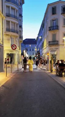 Cannes, Fransa - 24 Ağustos 2024: İnsanlar sokakta yürüyor, akşamları terasların yanında. Dikey