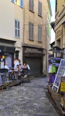 Cannes, Fransa - 26 Ağustos 2024: İnsanlar sokakta yürüyor, gün ışığında terasların yanında. Dikey