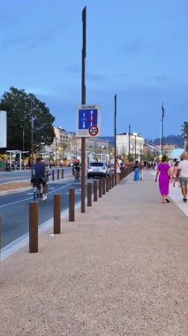 Cannes, Fransa - 26 Ağustos 2024: İnsanlar akşamları şehrin sokaklarında yürüyor. Dikey