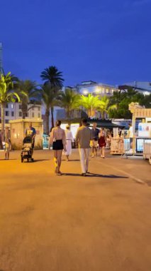 Cannes, Fransa - 26 Ağustos 2024: İnsanlar akşamları şehrin sokaklarında yürüyor. Dikey