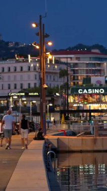 Cannes, Fransa - 26 Ağustos 2024: İnsanlar akşam saatlerinde Port de Cannes limanına yanaştı. Dikey