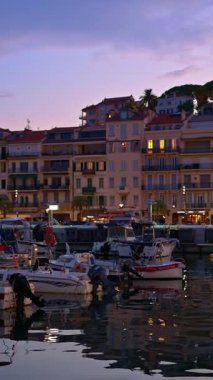 Cannes, Fransa - 26 Ağustos 2024: Gemiler arka planda binalarla birlikte akşamleyin Port de Cannes limanına yanaştı. Dikey