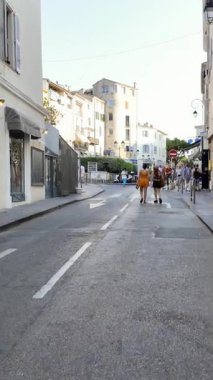 Antibes, Fransa - 29 Ağustos 2024: İnsanlar gün ışığında şehrin sokaklarında yürüyor. Dikey