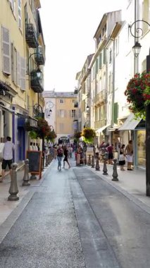 Antibes, Fransa - 29 Ağustos 2024: İnsanlar gün ışığında şehrin sokaklarında yürüyor. Dikey