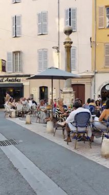 Antibes, Fransa - 29 Ağustos 2024: İnsanlar gün ışığında şehrin sokaklarında yürüyor. Dikey