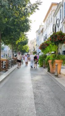 Antibes, Fransa - 29 Ağustos 2024: İnsanlar gün ışığında şehrin sokaklarında yürüyor. Dikey