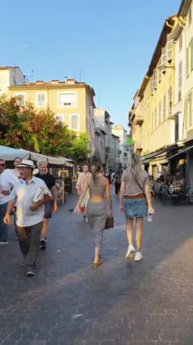 Antibes, Fransa - 29 Ağustos 2024: İnsanlar gün ışığında şehrin sokaklarında yürüyor. Dikey