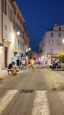 Antibes, Fransa - 29 Ağustos 2024: İnsanlar akşamları şehrin sokaklarında yürüyor. Dikey