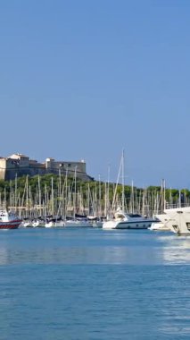 Antibes, Fransa - 29 Ağustos 2024: Gemiler arka planda Fort Carre ile Vauban Limanı 'na yanaştı. Dikey