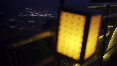 Fujikawaguchiko bakış açısı boyunca sakin bir akşam yürüyüşü çarpıcı bir şehir manzarasını gözler önüne seriyor. Fenerler hafifçe parıldıyor, gece atmosferine sıcaklık katıyor şehir ışıkları altta parıldarken.