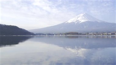 Fuji Dağı 'nın nefes kesici manzarası sakin suları yansıtıyor, yemyeşil bir hava ve açık bir öğleden sonra Japonya' da huzurlu bir atmosfer sergiliyor. Doğa, cennet manzarasını çevreledi. Kawaguchiko Gölü