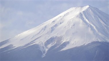 Görkemli Fuji dağı, temiz mavi gökyüzüne karşı el değmemiş karla kaplı bir zirve ile yakın mesafede. Manzara bu güzel manzaranın göz kamaştırıcı doğal manzarasını sergiliyor..