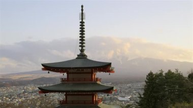 Chureito Pagoda, Fujikawaguchiko şehrine tepeden bakan ve güneş görkemli Fuji dağının arkasında batarken dimdik ayakta duruyor. Renkli mimari, akşam gökyüzü ile güzel bir tezat oluşturuyor..