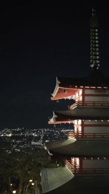 Chureito Pagoda gece aydınlandı, karanlık gökyüzüne karşı eşsiz mimari özelliklerini sergiledi. Dikey video