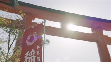 Kyoto, Japonya - 10 Nisan 2025: Geleneksel tapınak kapıları güneş ışığı girerken, ilkbaharda Fushimi-inari 'nin dingin atmosferini aydınlatıyor.