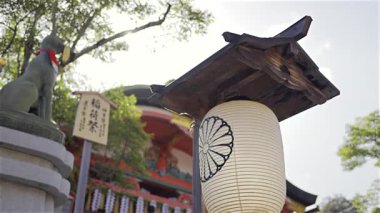 Kyoto, Japonya - 9 Nisan 2025: Japonya 'da Fushimi Inari geleneksel türbesine güzel bir fener asılır. Arka planda yürüyen insanlar