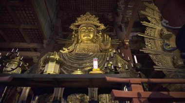 Nara, Japonya - 10 Nisan 2025: Ziyaretçiler Todai-ji Budist Büyük Tapınak Salonu 'ndaki görkemli altın Buda heykeline hayran kaldılar. Büyük Buda Salonunun içi
