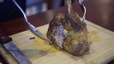 Bir adamın elini yakın, tahta bir tepside bir parça domuz doğrayın.