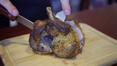 Bir adamın elini yakın, tahta bir tepside bir parça domuz doğrayın.